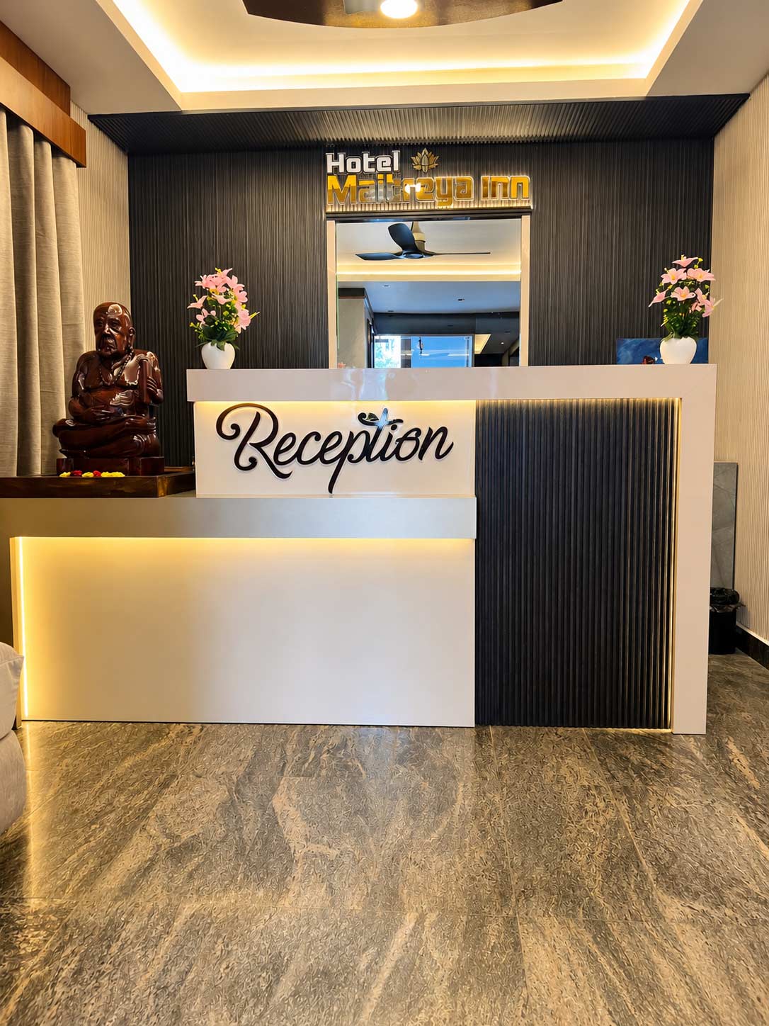 Hotel Maitreya Inn reception area in Vellore with modern front desk
